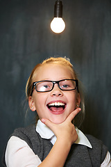 Image showing Student portrait, girl and lightbulb for solution, learning and wow, surprise or excited for future, ideas and knowledge in school. Child or kid with light bulb, emoji and black chalkboard for vision