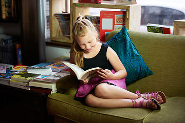 Image showing Child, girl on sofa and reading book for happy learning, education and funny story with knowledge or creative mind. Kid relax on couch with literature, English story and library in home living room