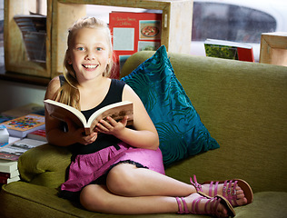 Image showing Child, happy portrait and reading book for learning, education and story, knowledge or creative mindset. Kid or girl relax on couch with literature, English language or library for home development