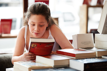 Image showing Girl child, reading book and education, story for knowledge or entertainment with customer in bookshop. Library, store and learning for development and growth, fiction or literature with young kid
