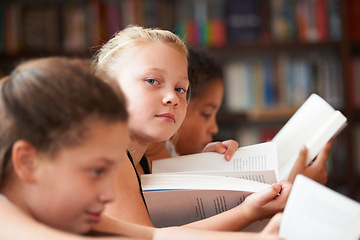 Image showing Girl, portrait and reading books in classroom for education, learning and English language, literature or school resources. Face of kid, students or children with novel, textbook or library textbook