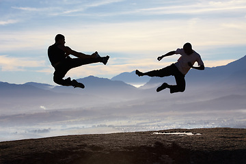 Image showing Flying, kick and karate men on mountain top for fitness, training or body, speed or power on sky background. Martial arts, taekwondo or MMA friends in nature with jump, fighting or sports exercise