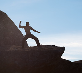 Image showing Karate, fitness man on mountain top for body training, power or defense practice on blue sky background. Martial arts, MMA and male taekwondo master in nature for exercise, sports or morning cardio