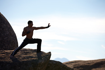 Image showing Fitness, karate and man on mountain top for body training, power or defense practice on blue sky background. Martial arts, MMA and guy taekwondo master in nature for exercise, sport or morning mockup