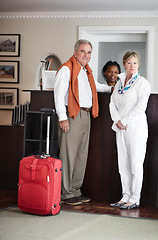 Image showing Travel, hotel and senior couple by reception to check in desk for love, anniversary and relax. Retirement, hospitality resort and elderly man and woman with concierge for bonding, holiday or vacation