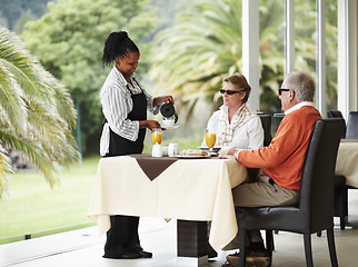 Image showing Waitress, coffee and senior couple on cafe patio on romantic date together at restaurant table. Old man, woman and server pouring drink at breakfast in luxury hospitality, hotel and relax on terrace.