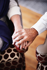 Image showing Old couple in living room, holding hands with love and support on retirement holiday together. Romantic marriage, senior man and woman on vacation in hotel lounge to relax, care and touch on armchair