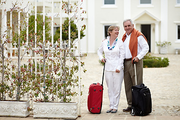 Image showing Portrait, suitcase and senior couple at hotel, happy on holiday or vacation at luxury resort. Smile, elderly man and woman with luggage at courtyard outdoor for tourism, travel or retirement together