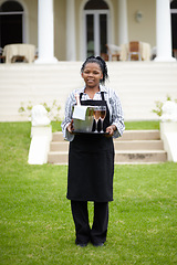 Image showing Black woman, waitress and carrying wine in garden, vinyard or resort in the countryside. Happy African female person with champagne, alcohol or bottle to serve people, reservation or customer service