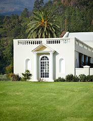 Image showing Landscape, garden and hotel with evergreen trees in nature for travel, sustainability and greenery in summer. Manor, lawn and environment background with grass, scenery and forest in countryside