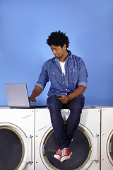 Image showing Washing machine, laptop and phone of a black man for laundromat, communication and reading email. Cleaning, typing and a male employee or management of laundry room from the internet with tech