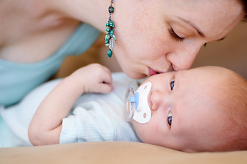 Image showing Kiss, love or mother with newborn or baby for care or bonding together to nurture child development. Home, face or single parent mom with infant for trust, growth or safety in family house to relax