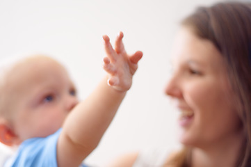 Image showing Happy, hand or mom blur with baby for love or bond together to nurture child development. Smile, play or single parent mother with a young newborn for trust, growth or safety in family house to relax