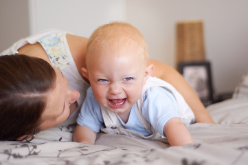 Image showing Happy, playing and a baby with mother on a bed for bonding, laughing and fun together. Smile, love and a family, child or mom in the bedroom for care, funny and playful in a house with a joke