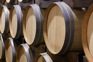 Image showing Background, wine cellar and barrel in brewery for beer production, alcohol manufacturing or whiskey fermentation. Closeup, wood cask container or liquor storage in winery, factory or distillery vault