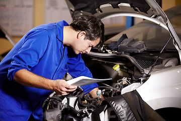 Image showing Car, service and repair with a mechanic man in a workshop as an engineer looking at the engine of a vehicle. Garage, report or quote with a young technician working under the hood of an automobile