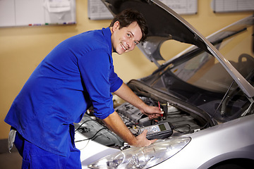 Image showing Portrait, car and repair with a mechanic man in a workshop as an engineer looking at the engine of a vehicle. Garage, service or quote with a young technician working under the hood of an automobile