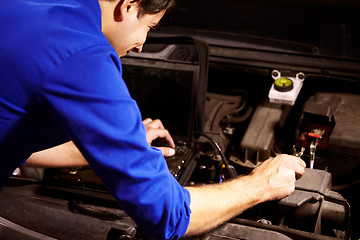 Image showing Hands, car or repair and a mechanic man in a workshop as an engineer looking at the engine of a vehicle. Garage, service or maintenance with a young technician working under the hood of an automobile