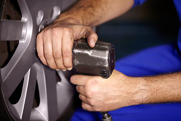 Image showing Hands, mechanic and change wheel in shop, electric drill and car service or auto repairs for maintenance. Technician, person and tire safety for automobile, rim and vehicle inspection in workshop