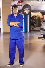 Image showing Professional, portrait and mechanic with arms crossed in a workshop for pride in a car. Smile, working and man in a garage for work, maintenance or building a vehicle for transportation or inspection