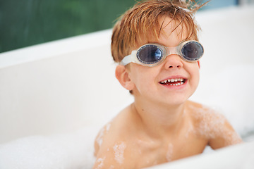 Image showing Smile, bath and a boy in swimming goggles having fun while cleaning for natural hygiene in water. Children, soap and bubbles with a happy young kid alone in the bathroom to wash for fresh skincare