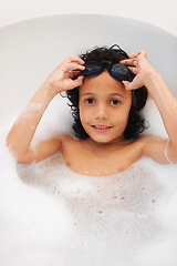 Image showing Portrait, kids and bath with a boy in goggles while cleaning his skin in the home for natural hygiene. Face, children and a happy young kid in the bathroom to wash with soap in water from above