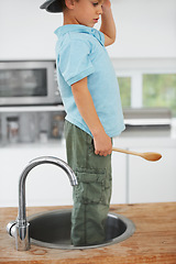 Image showing Kids, fantasy and a boy in the sink of a kitchen in his home for playing a game with his imagination. Children, creative and wooden spoon with a youth using his mind to invent fun in an apartment