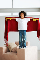 Image showing Portrait, children and a boy superhero in a costume on a sofa in the living room of his home for playing a game. Creative, growth and fantasy with a young kid in a cape for justice or safety cosplay