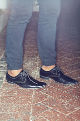 Image showing Shoes, legs and closeup of man feet by brick floor for an elegant, stylish and trendy outfit. Fashion, footwear and zoom of male person with luxury, classy and expensive style with jeans by pavement.