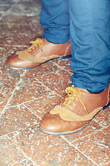 Image showing Footwear, style and closeup of man feet by brick floor for elegant, stylish and trendy outfit. Fashion, shoes and zoom of male person with luxury, classy and expensive fashion with jeans by pavement.