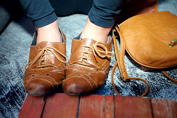 Image showing Closeup, leather and feet with shoes for fashion, vintage style or aesthetic and bag for lifestyle or trend. Person, legs and flats for creativity, retro or unique footwear with handbag on background