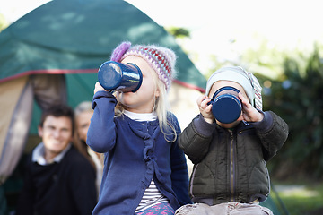 Image showing Children, siblings and together for drinking while camping in Sweden, woods or forest on trip. Girl, boy and enjoyment of delicious, beverage or hot cocoa with cup, family and adventure in nature