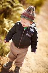 Image showing Happy, walking and child in nature on adventure, hiking and freedom on dirt path to explore. Countryside, childhood and young, curious and excited kid outdoors on holiday, vacation and travel