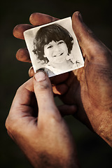 Image showing Hands, holding picture of kid and portrait, nostalgia or remember memory of family or child isolated on black background in studio. Closeup, photo of boy and dirty fingers of homeless man in poverty