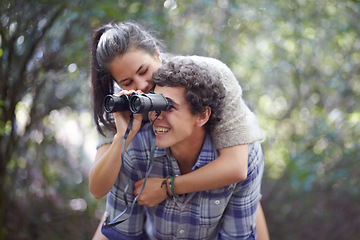Image showing Man, woman and piggyback in forest with binocular for travel, adventure or sightseeing in nature with happiness. Couple, people and tourist hiking outdoor in woods for experience, holiday or vacation