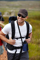 Image showing Man with smile, backpack and friends on hiking adventure in mountain with nature, freedom or wellness. Travel, trekking and person in countryside with happy people on natural outdoor journey together