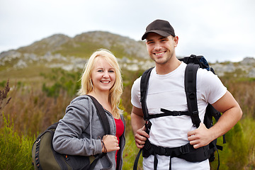 Image showing Backpack, portrait of woman and man with smile on hiking adventure in mountain with nature walk, freedom or wellness. Travel, trekking and happy couple of friends on natural outdoor journey together.