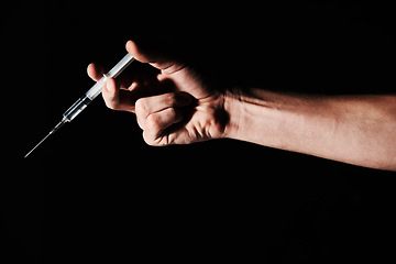 Image showing Needle, drugs in hand and person on black background with medicine, insulin or vaccine in studio for health. Pharmaceutical, healthcare or addiction with antibiotic or heroin, syringe and injection