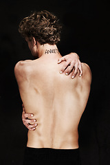 Image showing Back, anxiety and body of man in studio isolated on a black background. Rear view, worry and person with psychology trauma, mistake or fear, frustrated at depression and mental health tattoo or words