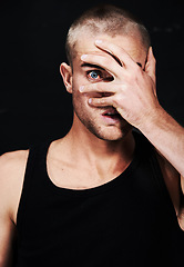 Image showing Portrait, anxiety and man peek through hands in studio isolated on a black background. Face, scared and person peep through fingers, spy or paranoid at horror, fear danger or stress for mental health