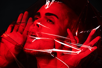 Image showing Man, red plastic and suffocating in studio isolated on black background. Polyethylene, film or person with depression, social isolation and anxiety, stress or mental health crisis, psychology or neon