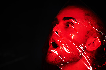 Image showing Man, red plastic and suffocate in studio isolated on a black background mockup. Polyethylene, film and person with depression, fear and anxiety, stress and mental health crisis, psychology and neon