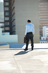 Image showing Businessman, suicide and rooftop with stress, depression and mental health with suitcase outdoor in city. Professional, person or employee and back on roof of building with anxiety, risk and crisis