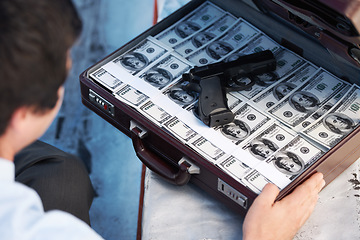 Image showing Businessman, gun and briefcase with money for crime, corruption, thief and fraud outdoor for financial crisis. Professional, man and weapon with cash, finance and secret for laundering, scam or loan