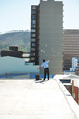 Image showing Back, financial freedom and money rain with a man in the city, throwing cash during a summer day. Finance, success or raining dollars with a business person on the roof of a building in an urban town