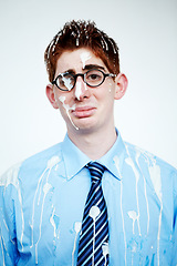 Image showing Portrait, bird poo and a business man in studio on a white background for an unlucky or misfortunate mishap. Sad, depression and bad luck with an unhappy young employee in glasses after an accident