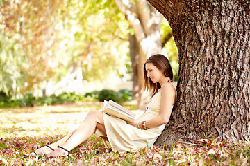 Image showing Woman, book and reading outdoors to relax, peace and calm in nature for travel adventure in New York. Happy female person, freedom and break by tree, literature and fiction in park, story or novel