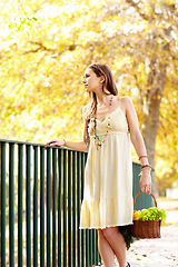 Image showing Woman, basket or park by fence in autumn on holiday vacation in countryside, nature or France. Thinking, vegetables or person with healthy diet outdoors for fresh air, wellness or break to relax