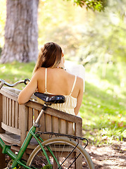 Image showing Bicycle, bench or woman in park to relax for wellness, nature or health on holiday vacation in autumn. Amsterdam, back or female person resting on break alone with bike for eco friendly transport