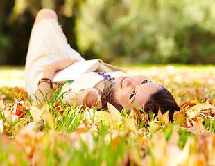 Image showing Portrait, book and woman relax in park with novel in nature learning for education as student outdoor on campus. University, portrait and young person with textbook on grass field for scholarship